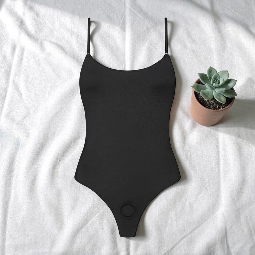 Black swimsuit on a white surface with a potted plant